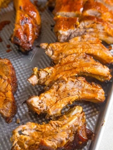 Oven Baked Ribs, sliced, on a pan with extra glazing