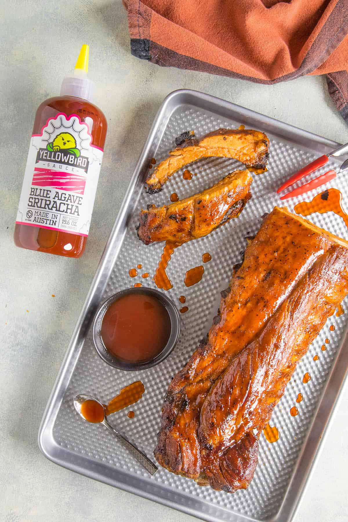 Oven Baked Ribs served on a pan with hot sauce.