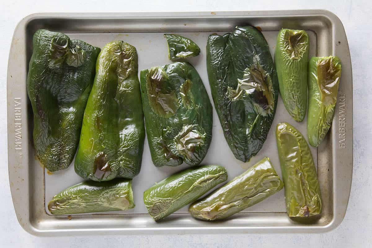 Poblano peppers and jalapeno peppers, sliced and on a baking sheet, roasted