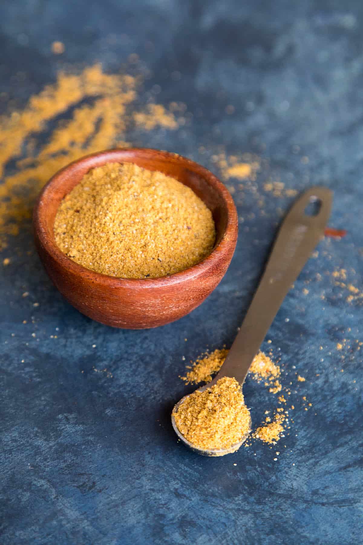 Vindaloo curry powder in a bowl and on a measuring spoon.