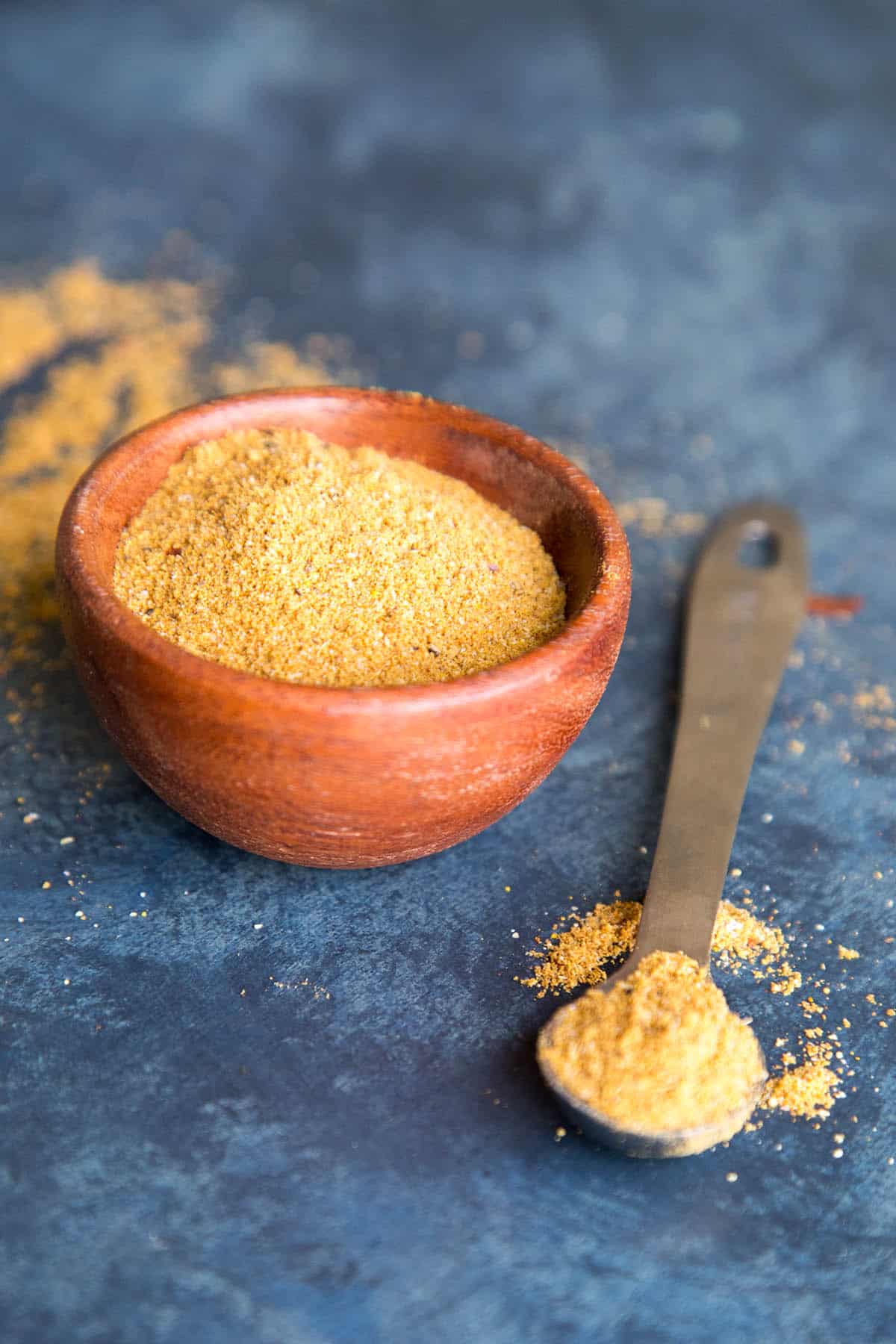 Vindaloo curry seasoning blend in a bowl and on a measuring spoon.