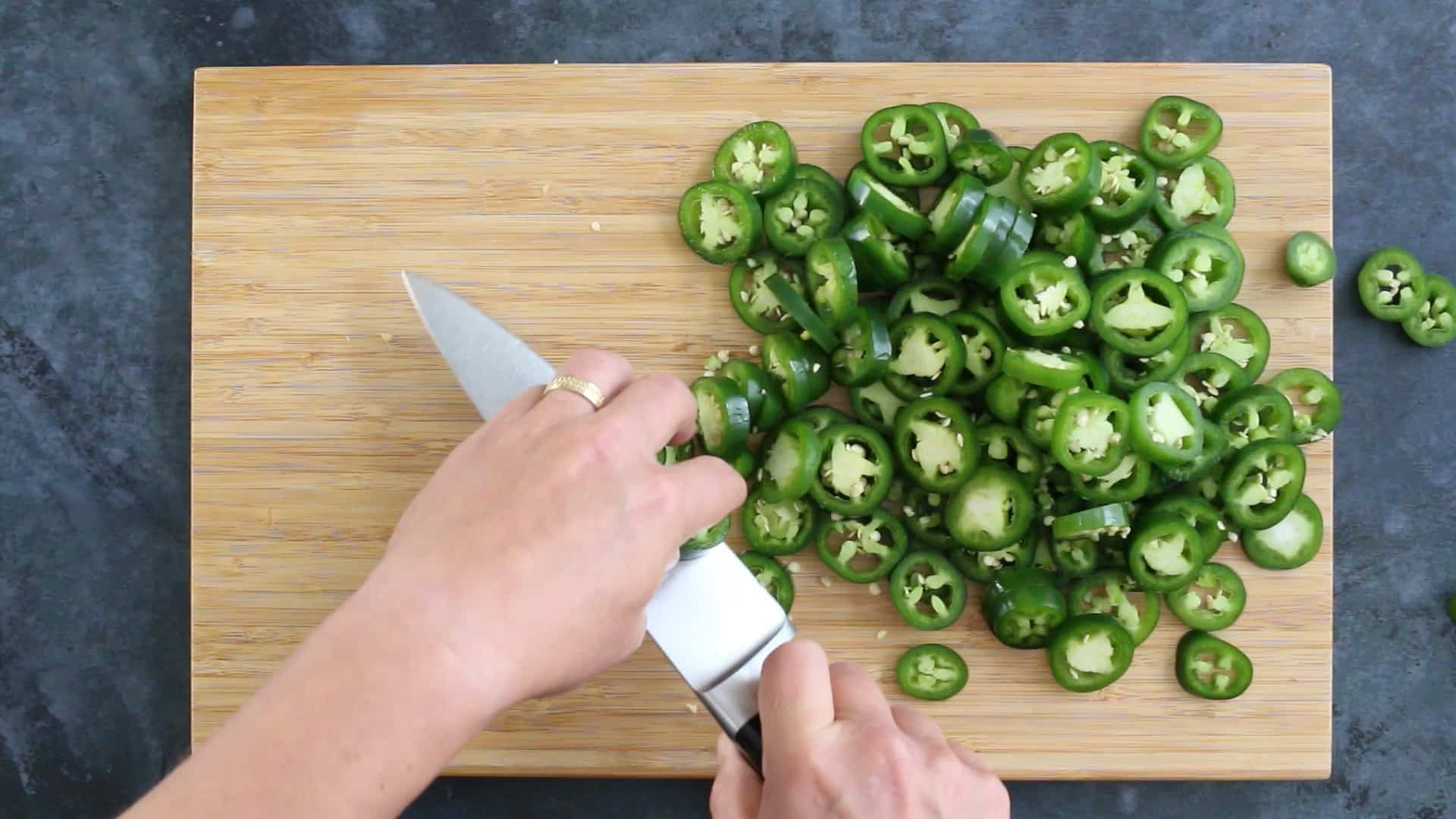 Chopping jalapeno peppers in a pan to make Candied Jalapenos (Cowboy Candy)