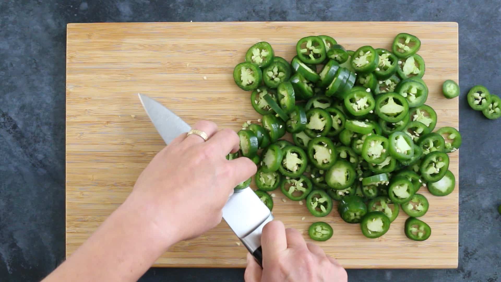Candied Jalapenos Recipe (Cowboy Candy) Chopping jalapeno peppers in a pan to make Candied Jalapenos (Cowboy Candy)