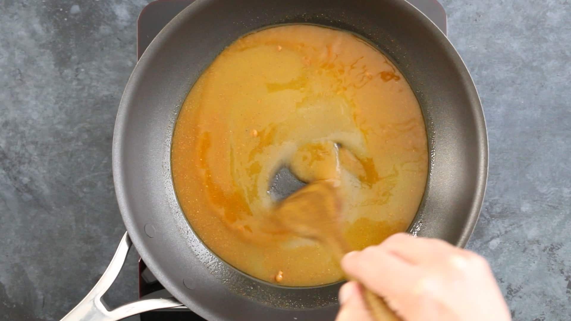 Candied Jalapenos Recipe (Cowboy Candy) Stirring the seasoned simple sugar in a pan