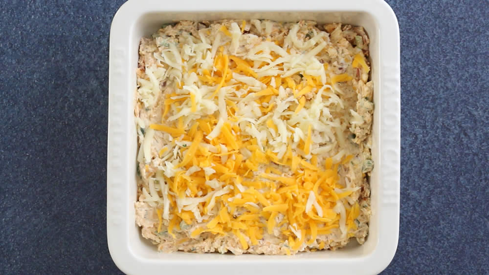 Bacon Jalapeno Popper Dip, topped with cheese, ready for the oven