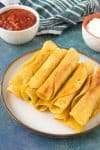 Chicken Taquitos - stacked on a plate with salsa