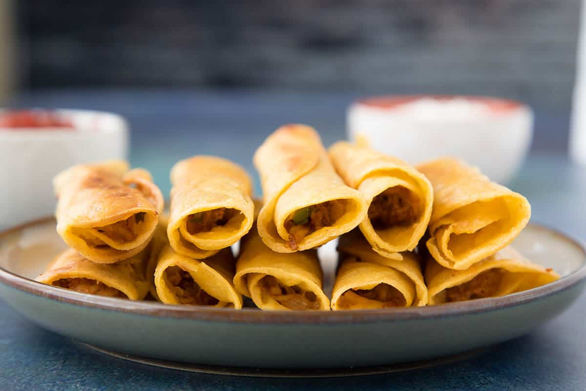 Chicken Taquitos - Stacked up on a plate.