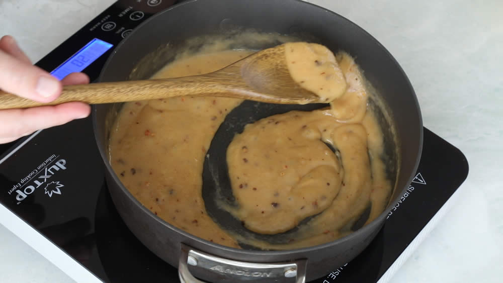 Stirring the seasoned, thickened roux