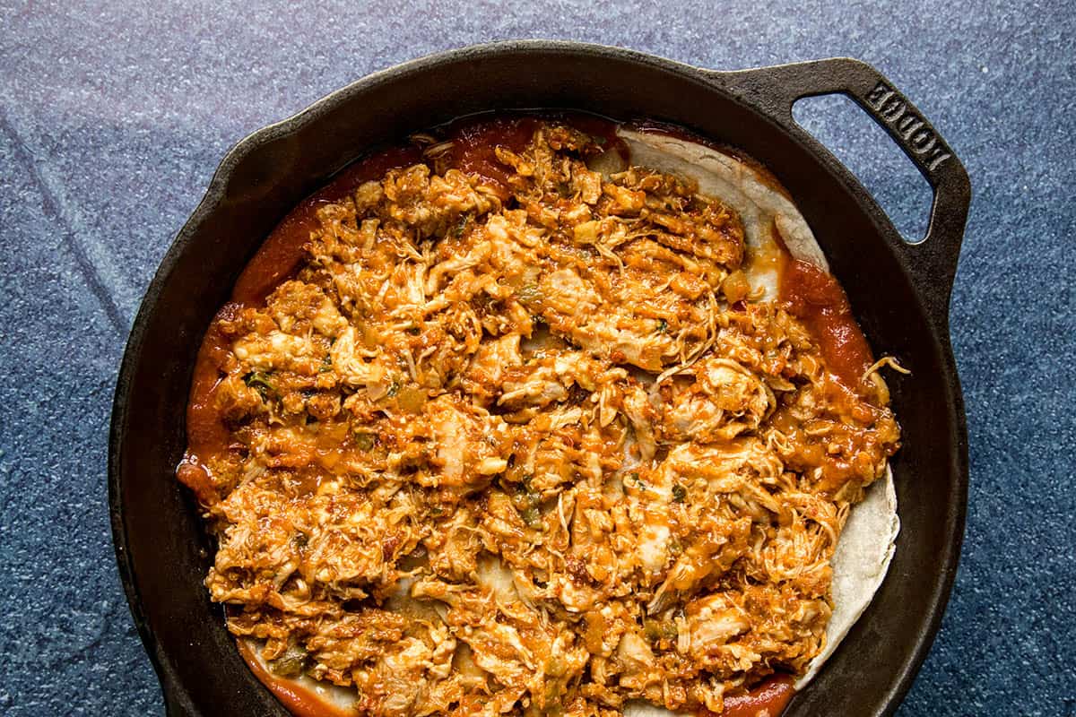 Adding chipotle chicken to the Chipotle Chicken Enchilada Casserole