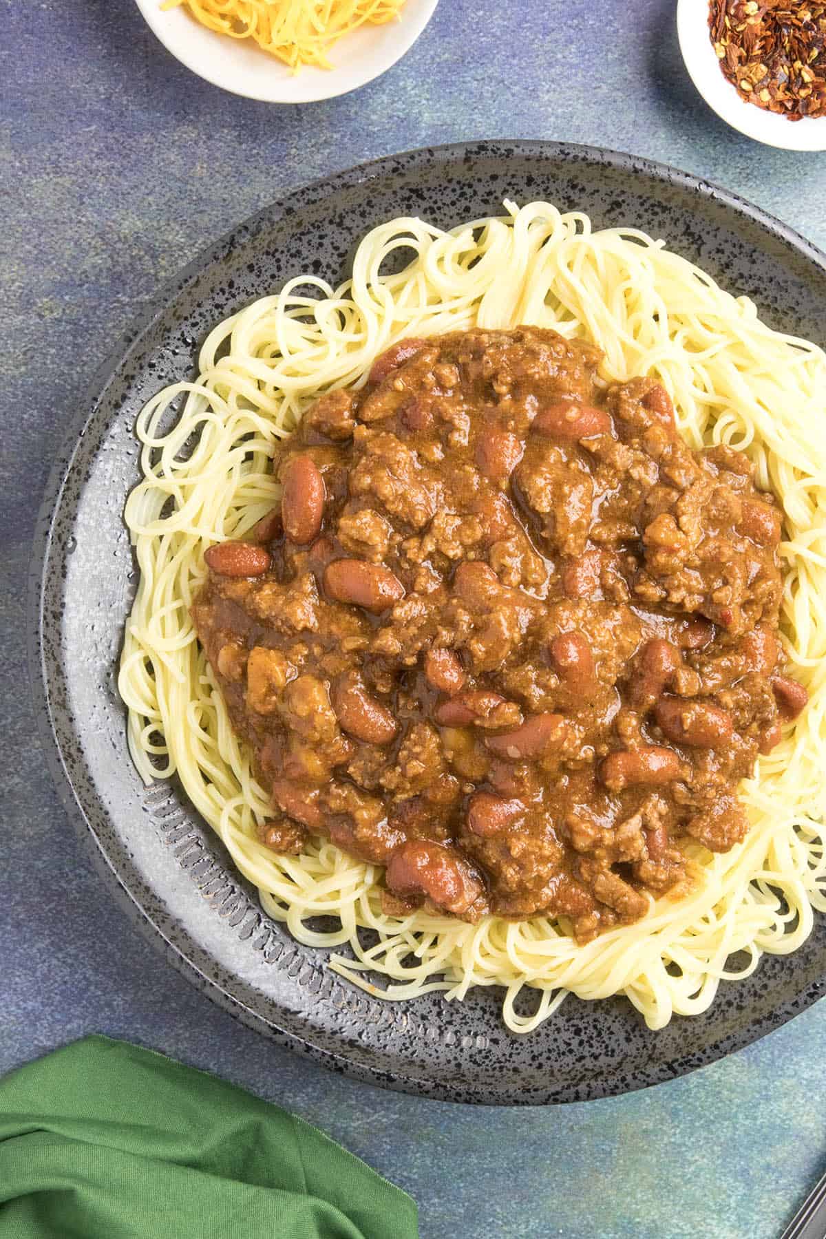 Cincinnati Chili Recipe Cincinnati Chili on a plate of noodles, ready to eat