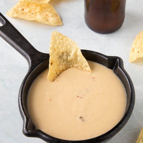 Creamy Beer Cheese served in a bowl with chips around it