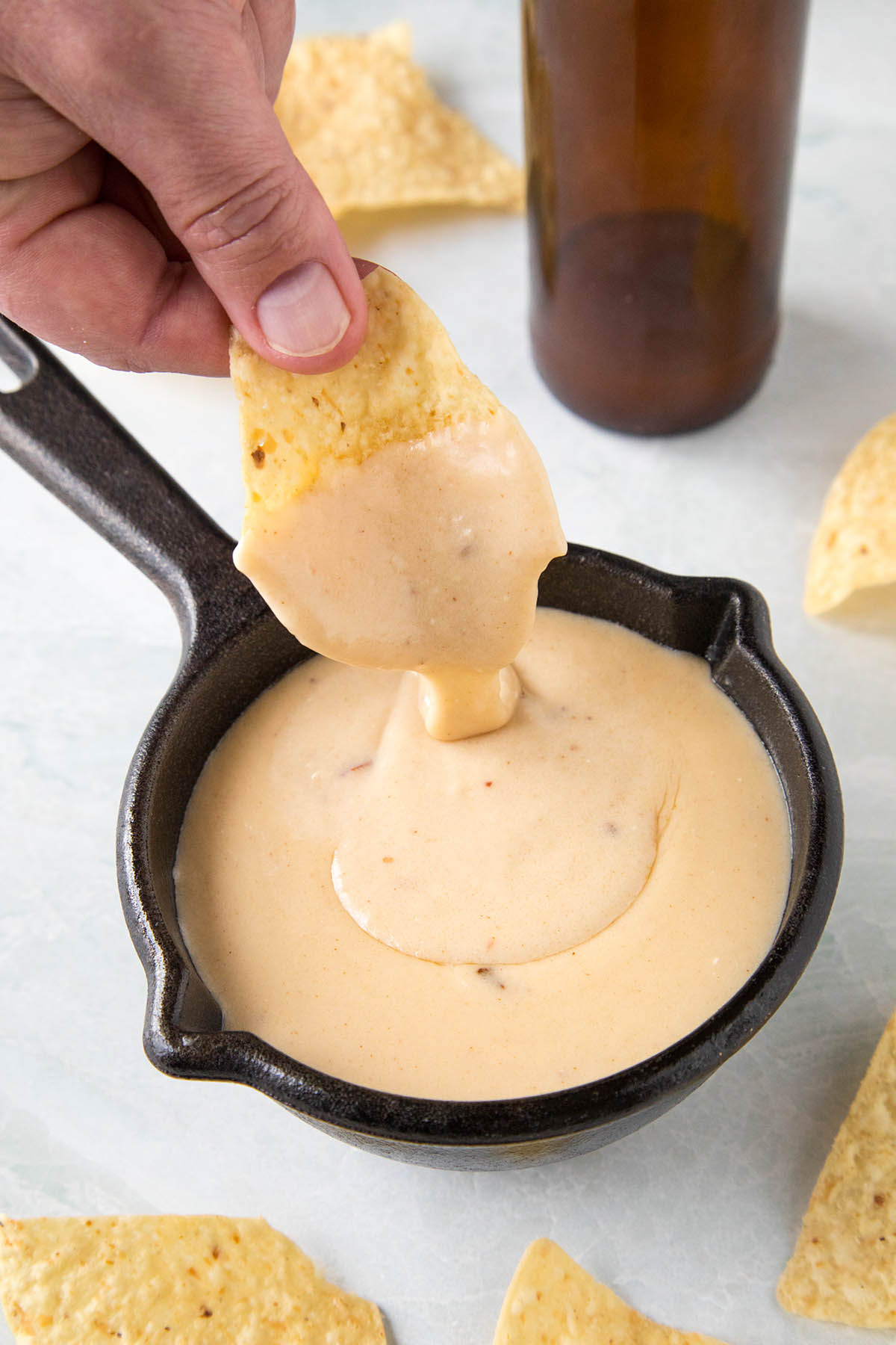 Dipping a chip into our Creamy Beer Cheese