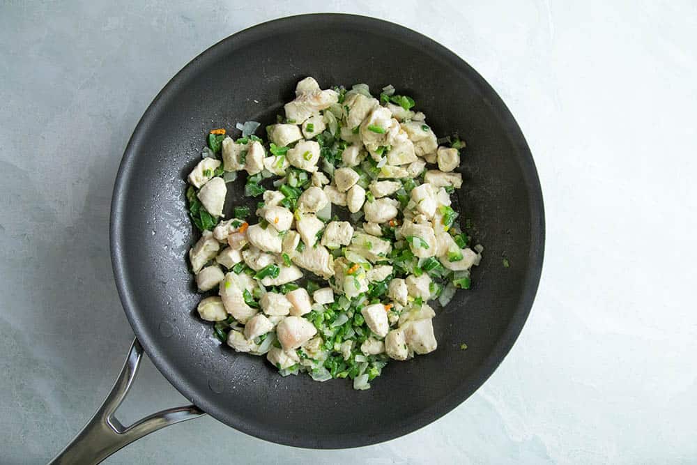 Cooking chicken, peppers and onions in a pan