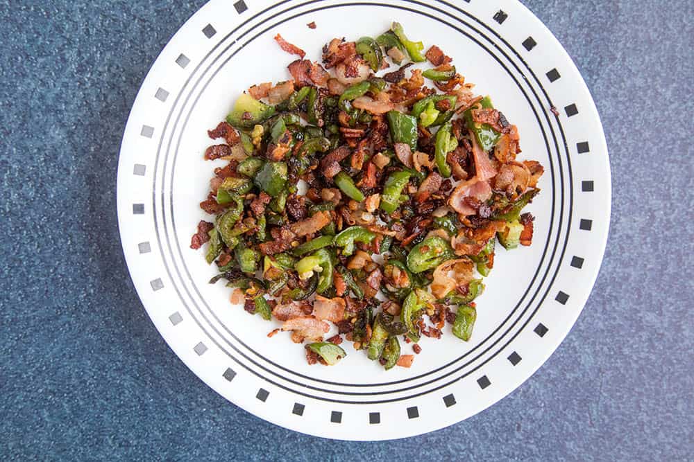 Reserved cooked bacon and jalapeno peppers on a plate