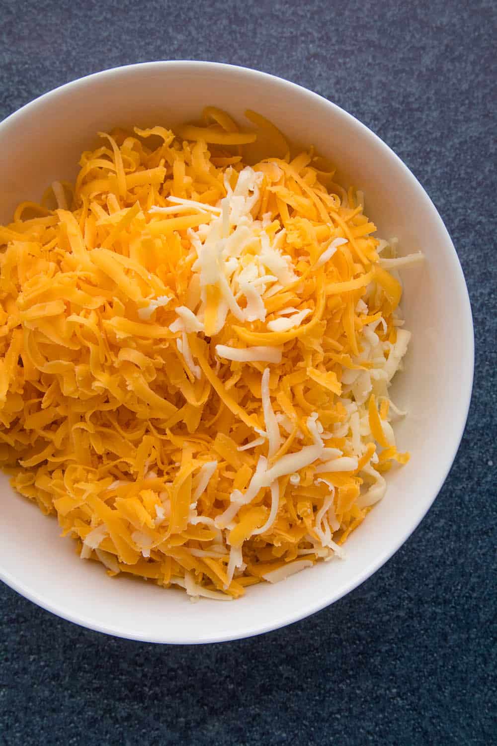 Loads of shredded cheese for our Creamy Jalapeno Popper Mac and Cheese - Recipe