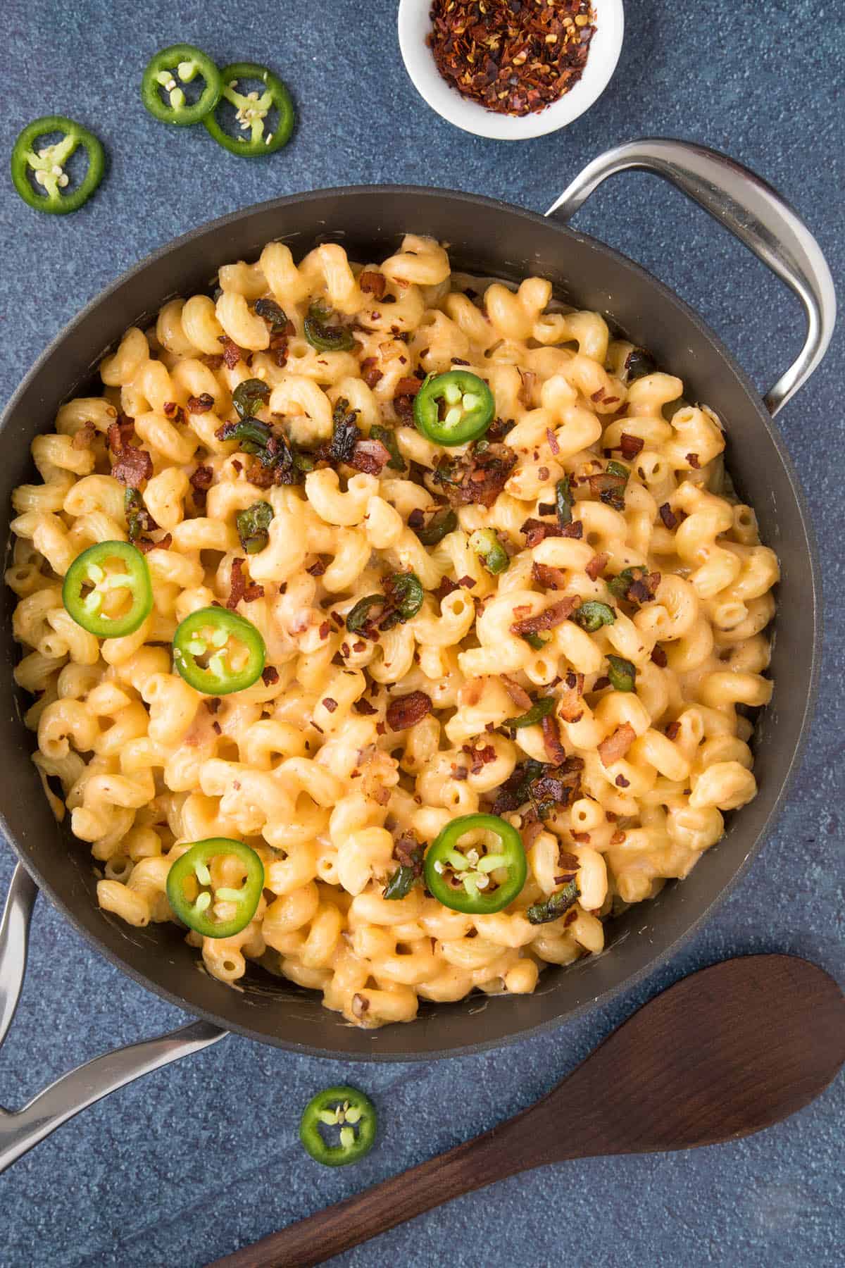 Creamy Jalapeno Popper Mac and Cheese in a pan, with extra jalapeno pepper slices over the top