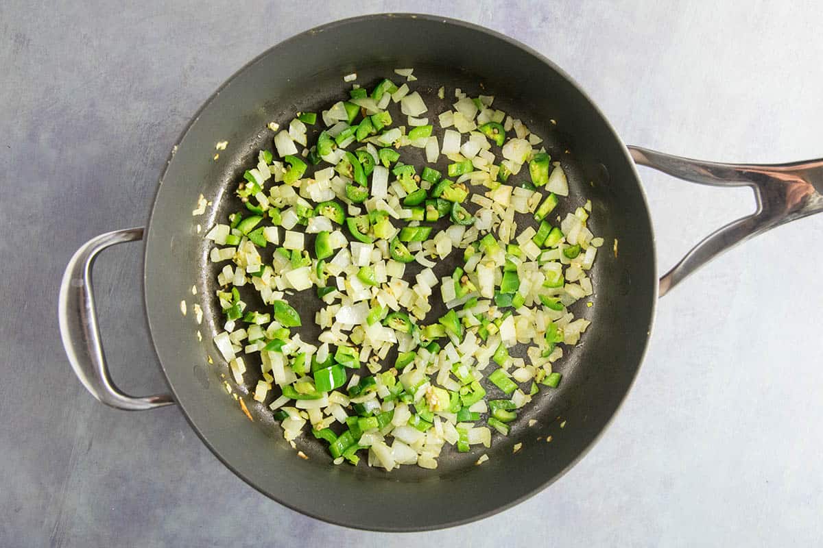 Cooking down onions and peppers in a hot pan with oil