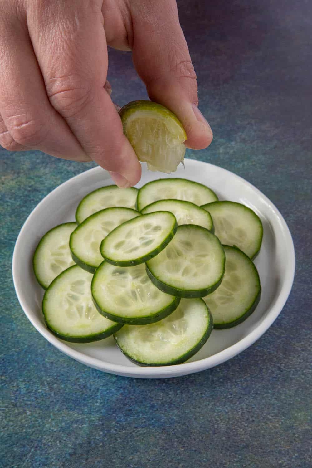 Drizzling the cucumbers with fresh lime juice