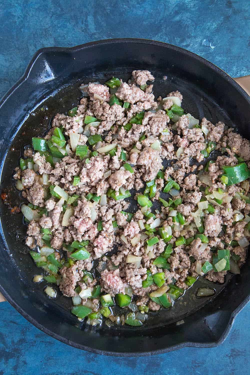 Cooking down the ground beef with onions and peppers.