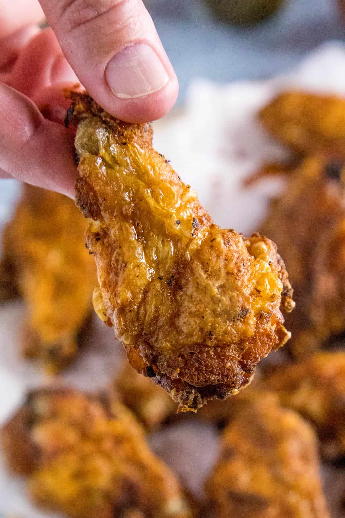 Mike holding a crispy baked chicken wing drummy