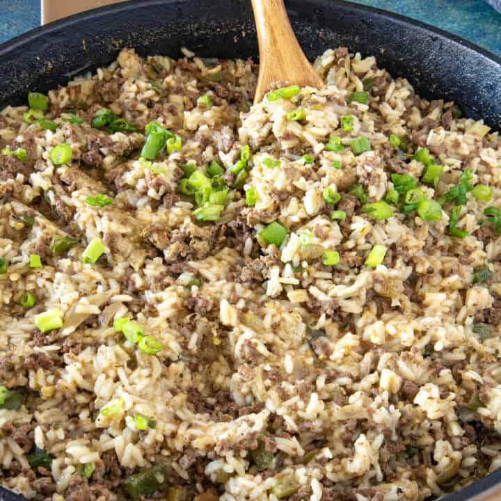 Mike serving a scoop of Cajun Dirty Rice from the hot pan