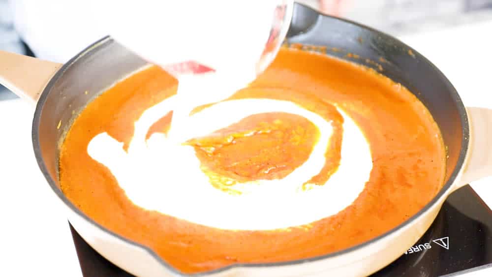 Swirling heavy cream into the butter chicken curry sauce
