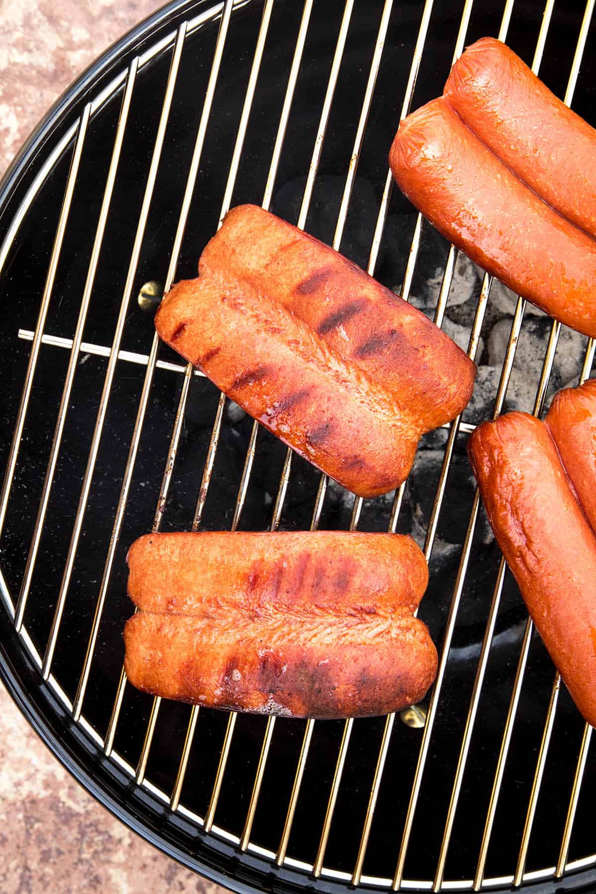 Charred hot dogs on the grill.