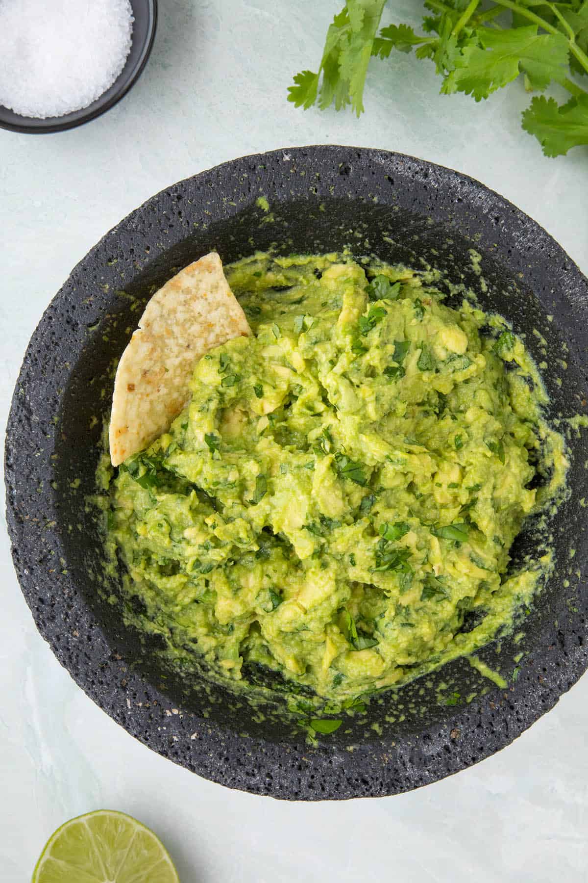 Fresh guacamole in a bowl with a chip