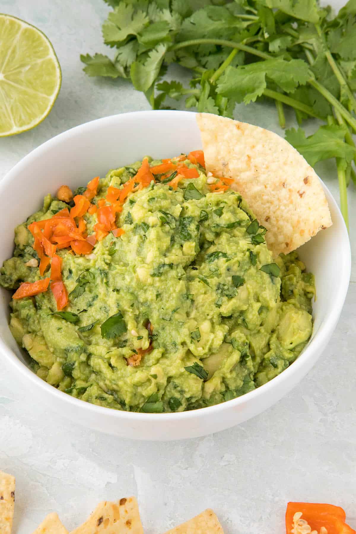 Spicy guacamole with habanero peppers in a bowl, with a chip, waiting for you