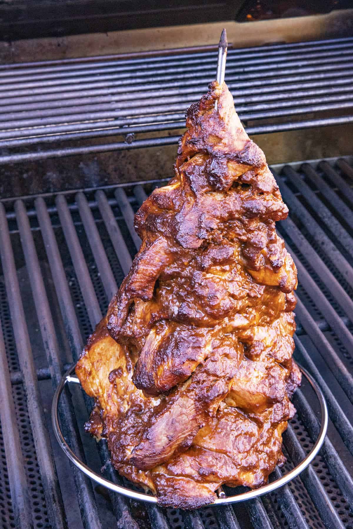 Grilling pork al pastor on a vertical skewer