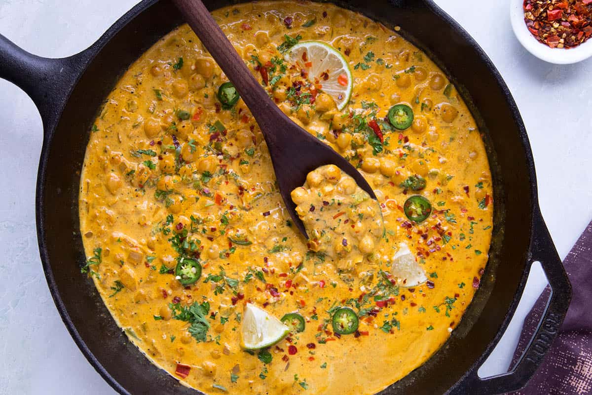 Chickpea Curry in a pan, with a serving spoon