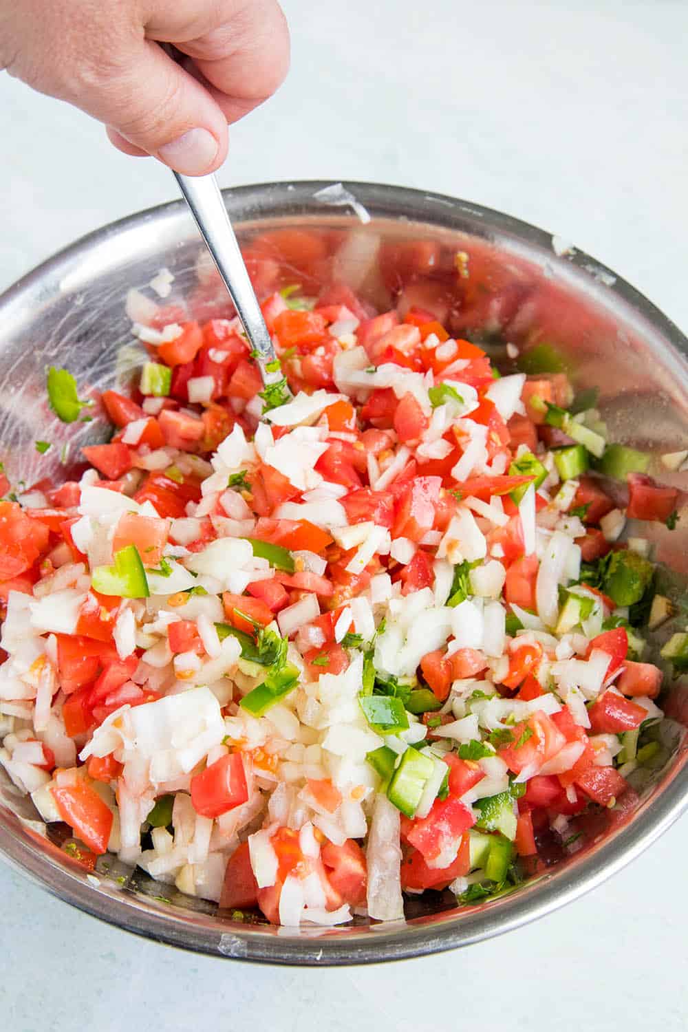 Pico de Gallo ingredients, mixing with a spoon