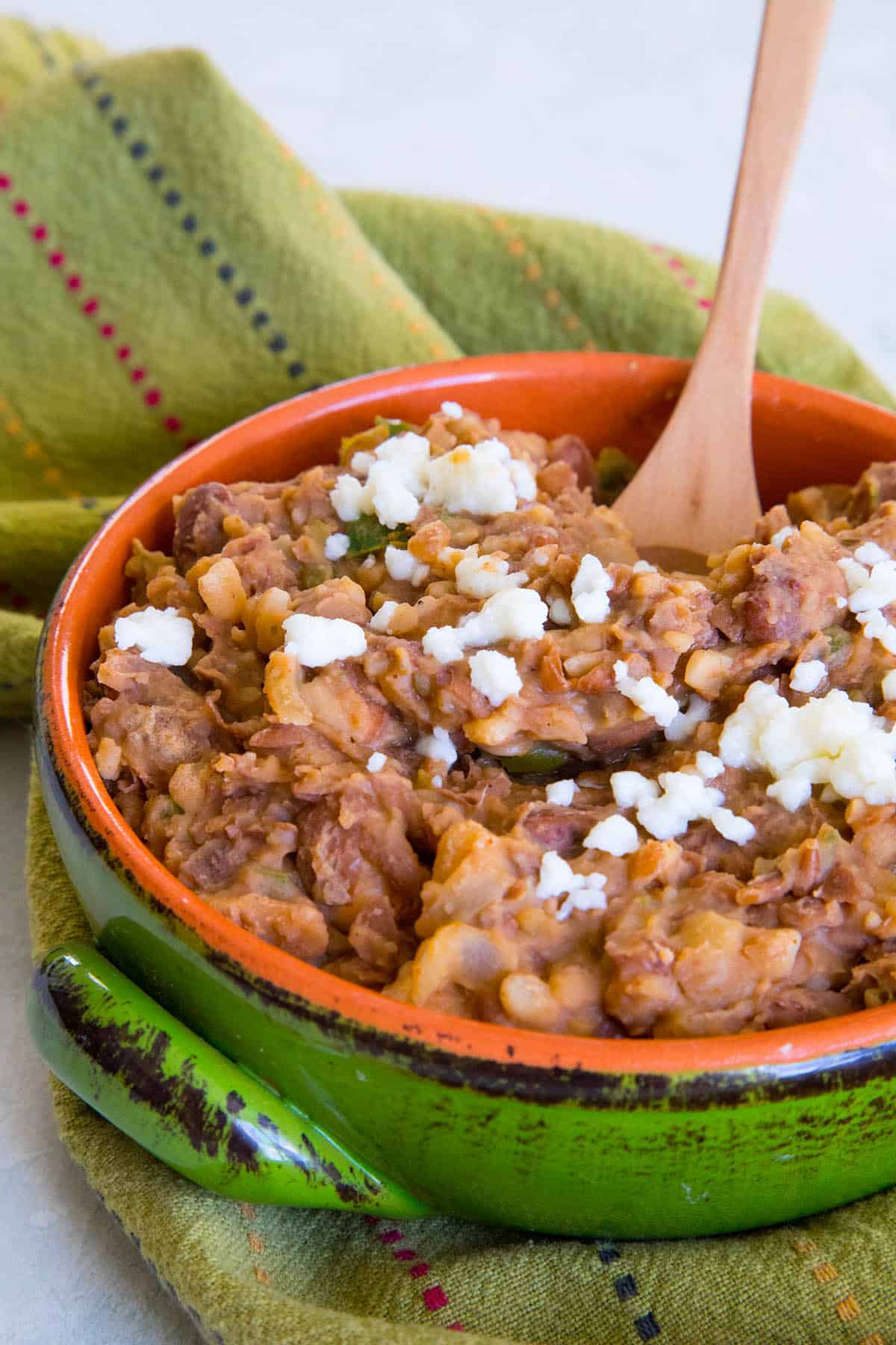 Easy Homemade Refried Beans in a bowl, with a serving spoon