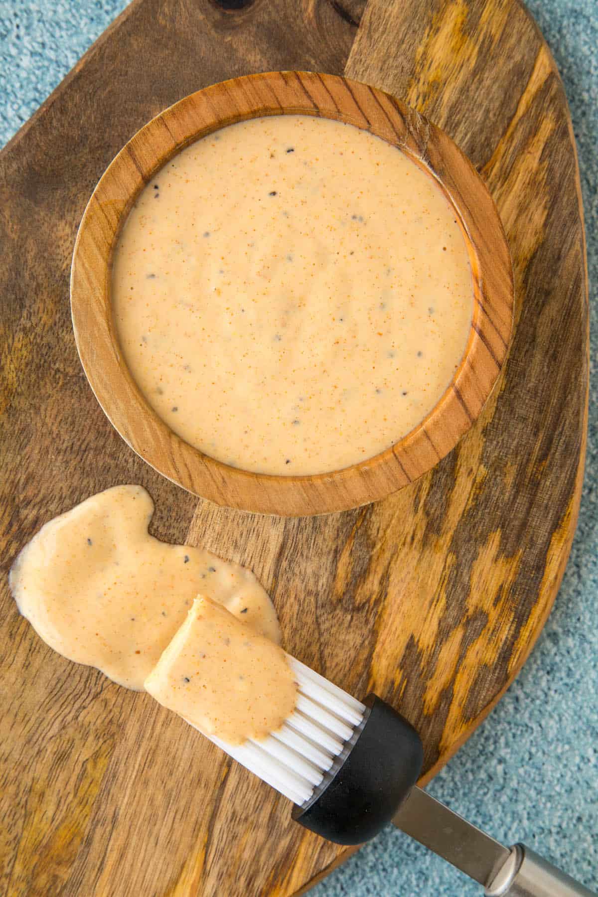 Alabama White BBQ Sauce in a bowl and on a brush