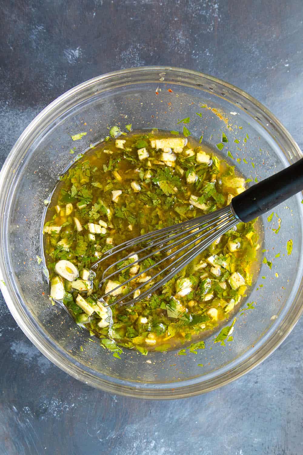 Whisking together the carne asada marinade ingredients in a bowl