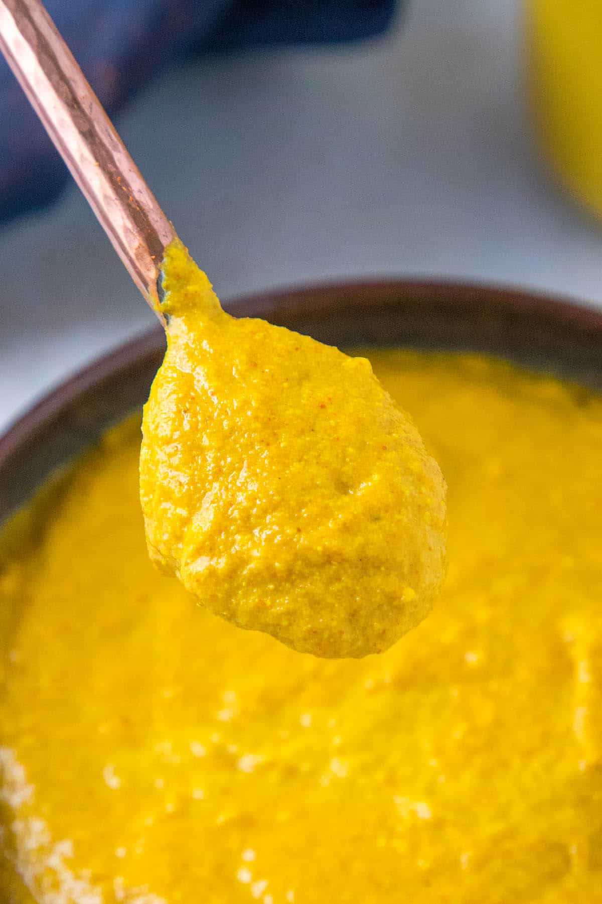 Homemade Yellow Mustard on a spoon, close up