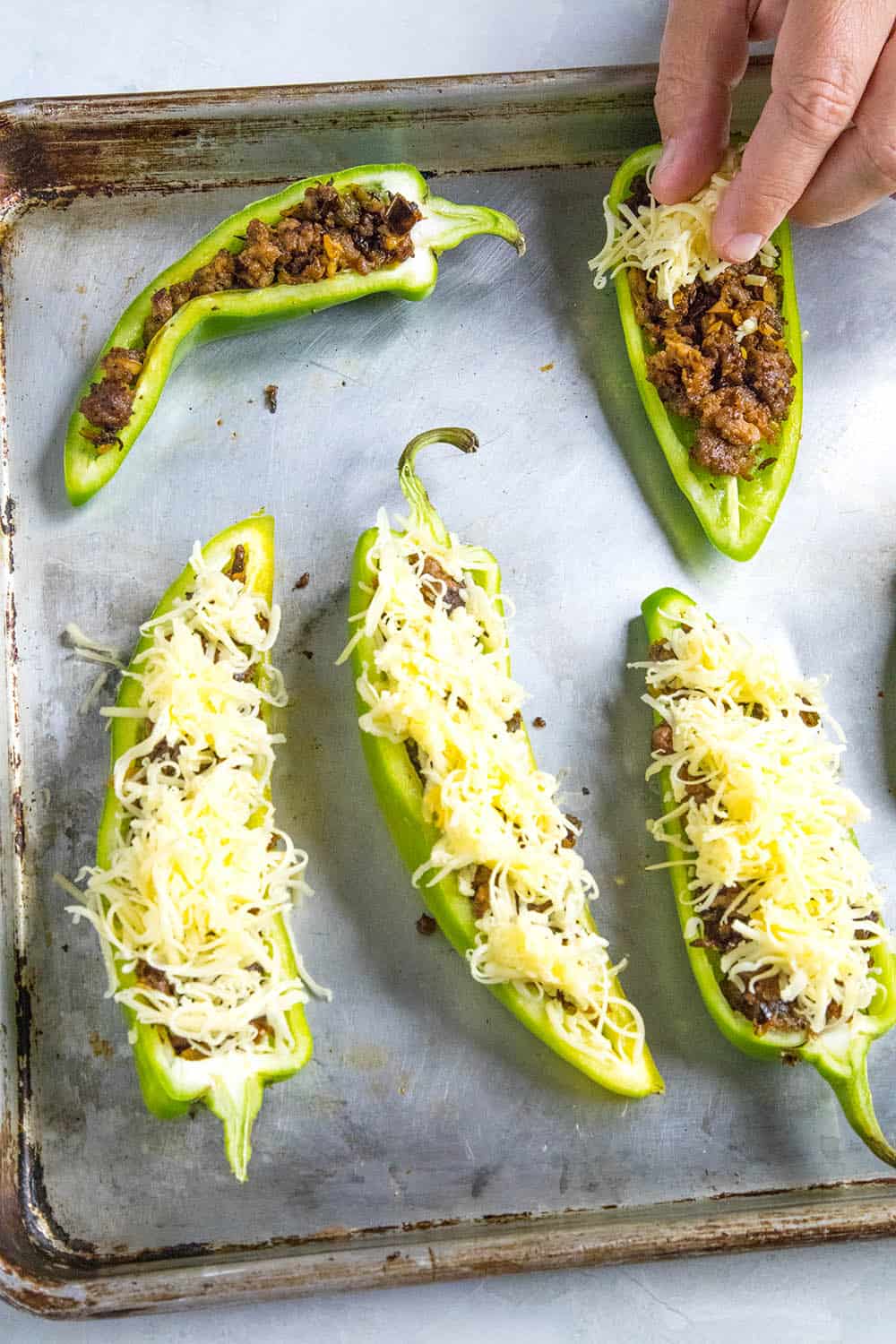 Adding cheese to our stuffed anaheim peppers