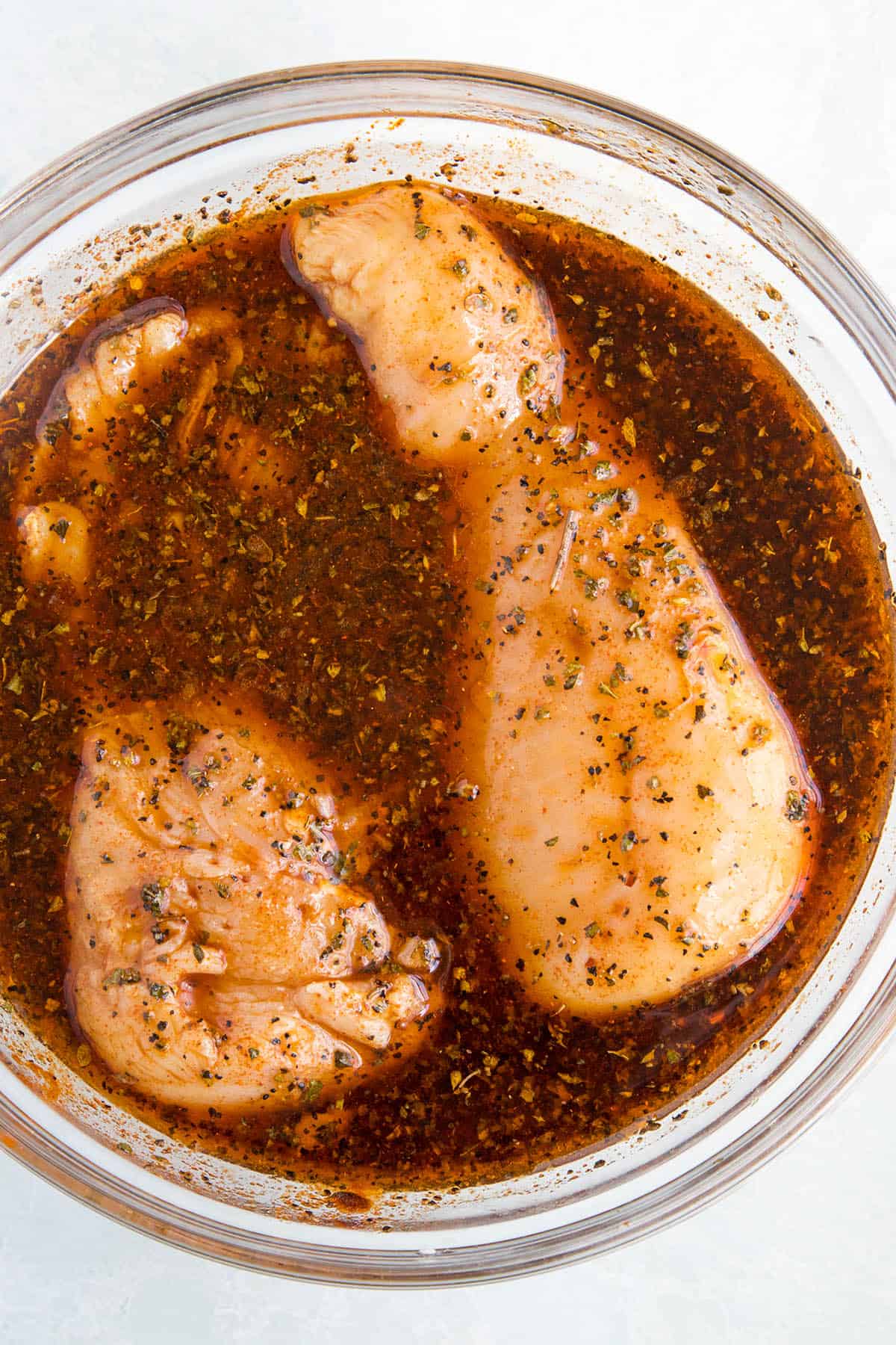 Chicken marinating in a bowl