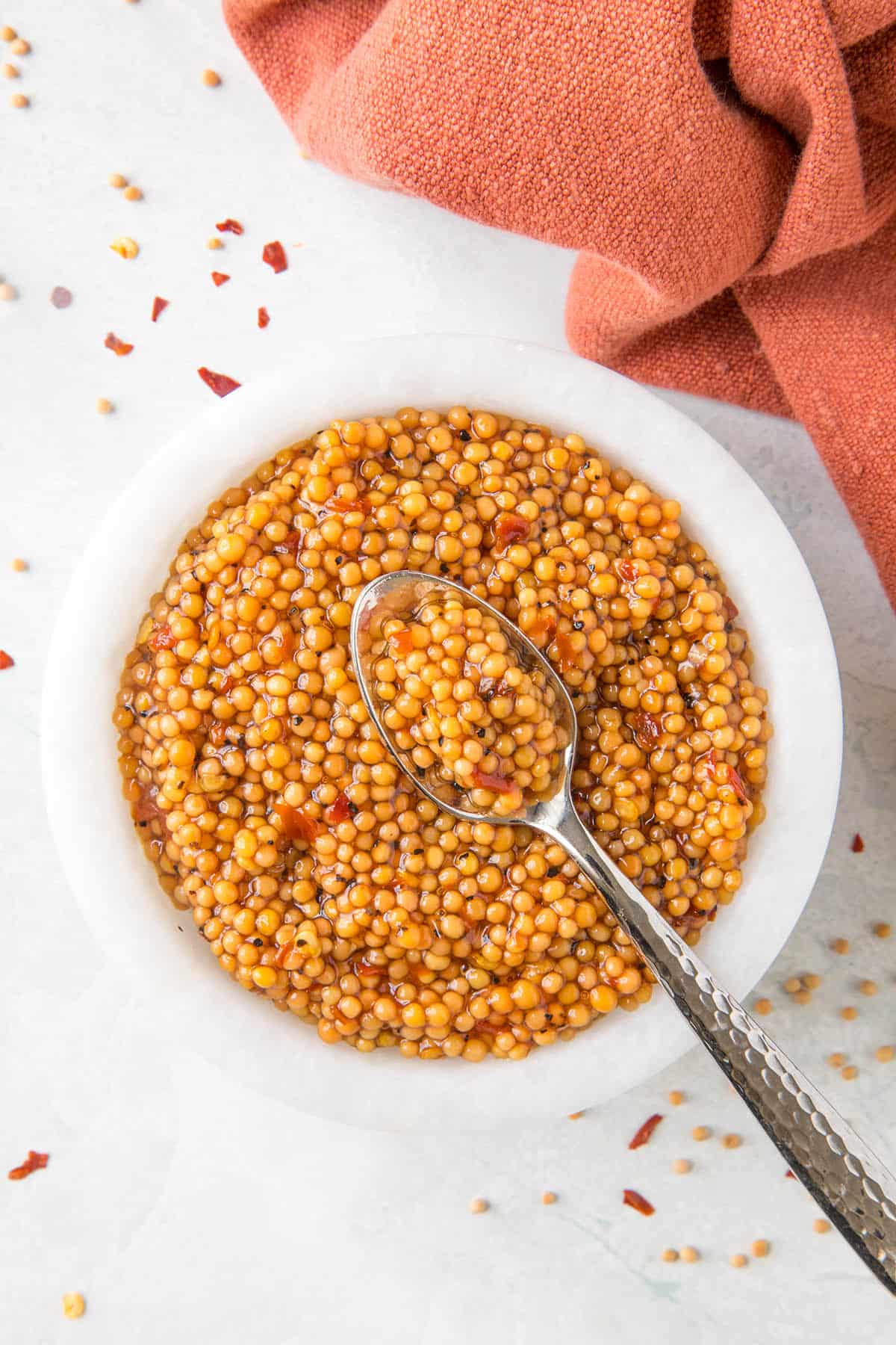 Pickled Mustard Seeds in a bowl with a serving spoon