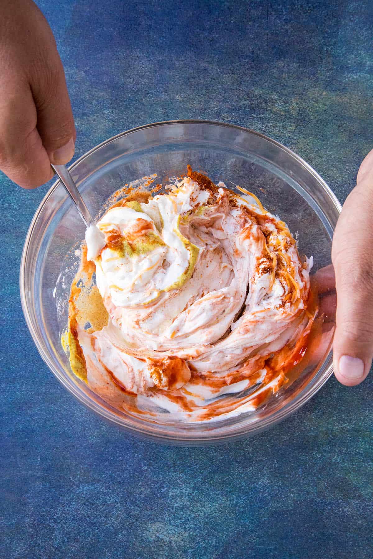 Mixing sour cream dip in a bowl.