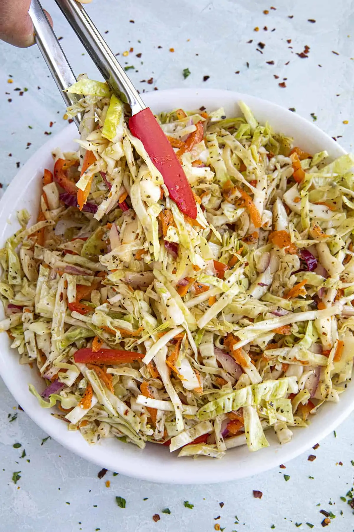 Mike scooping up Vinegar Coleslaw with tongs