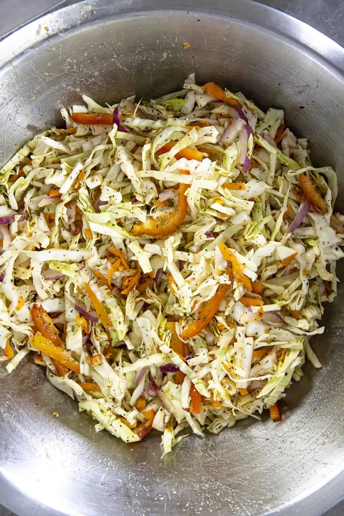 Tossing the Vinegar Coleslaw ingredients with the vinaigrette in a bowl