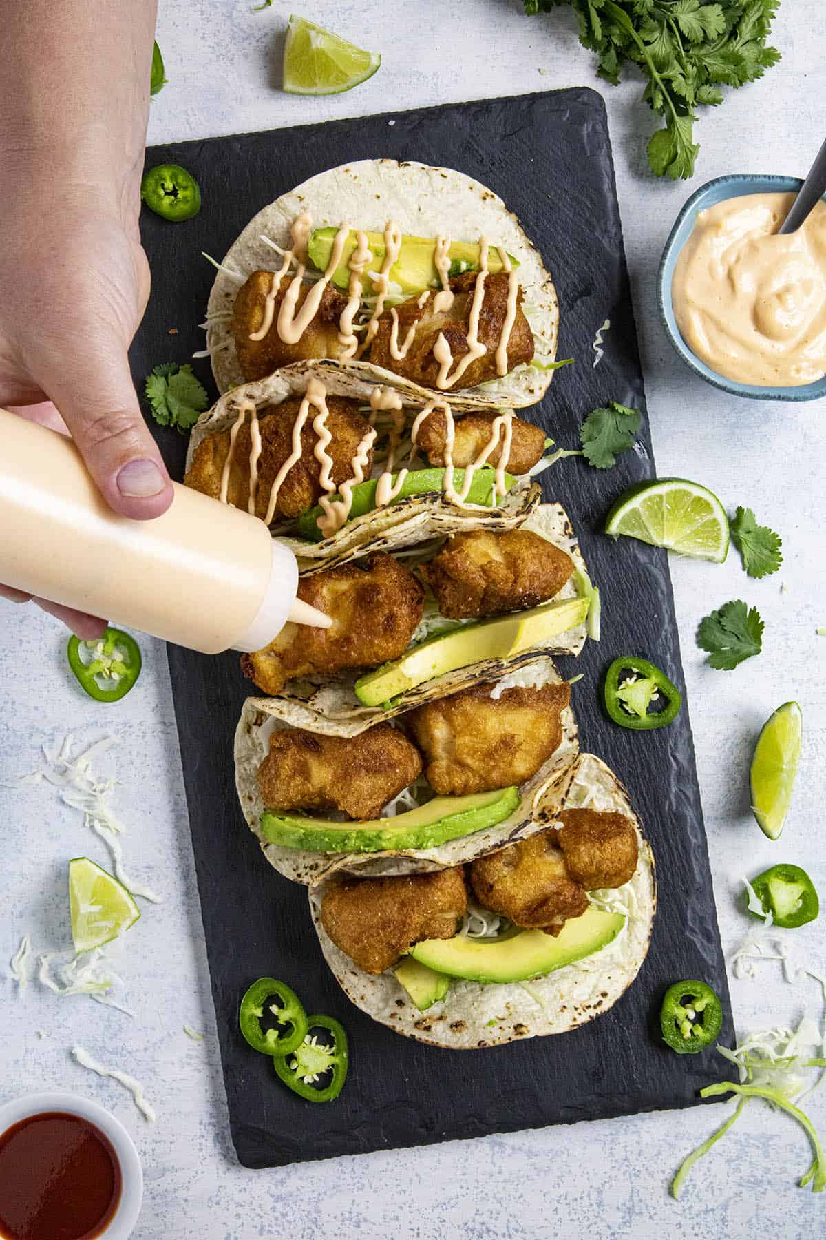 Adding sauce to our baja fish tacos