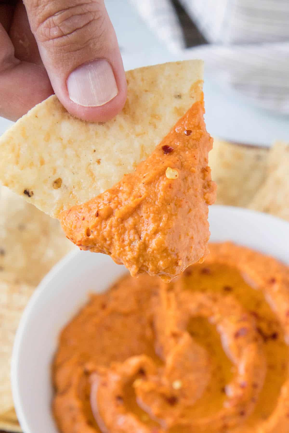 Creamy White Bean Dip with Harissa on a tortilla chip