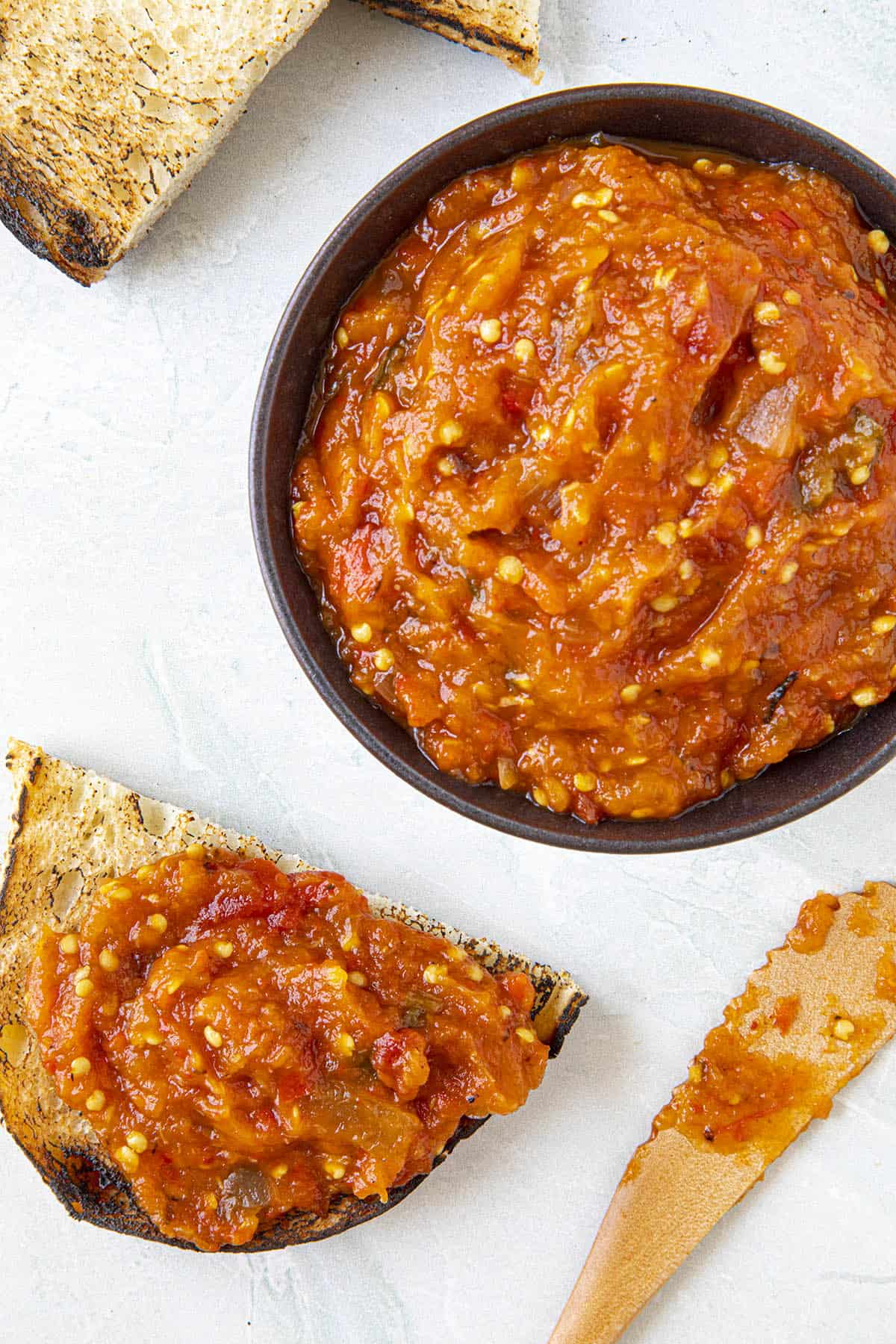 Zacusca spread on bread and in a bowl