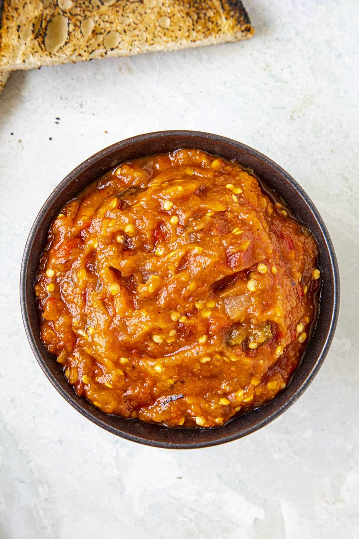 Thick and delicious zacusca in a serving bowl with some bread