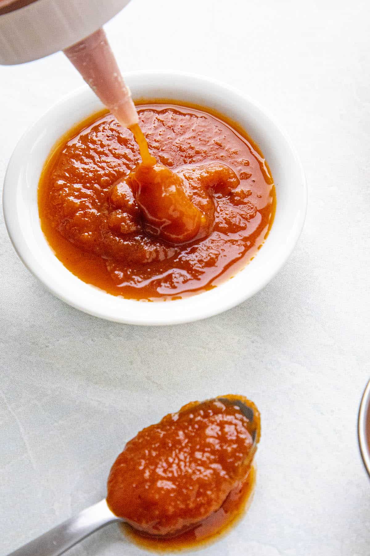 Squirting some homemade ketchup into a bowl