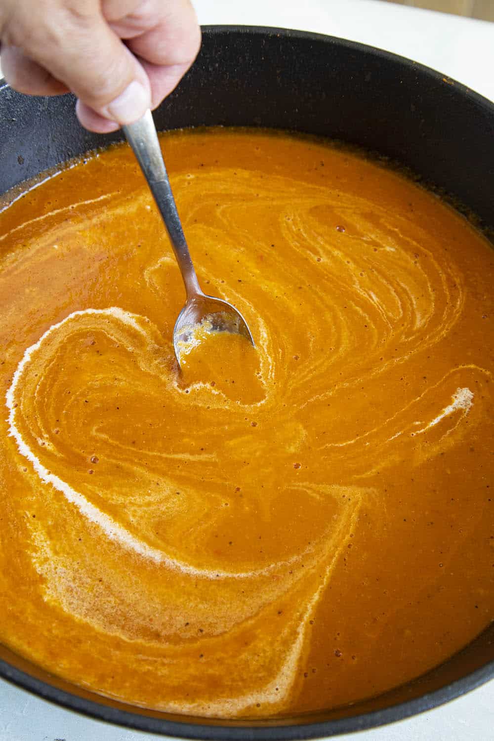 Swirling heavy cream into my roasted tomato soup