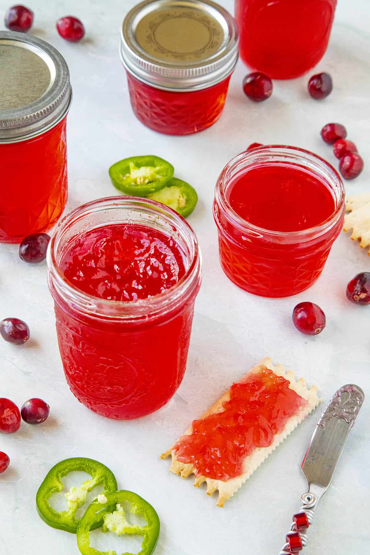 Cranberry Jalapeno Jelly in jars and spread onto a cracker