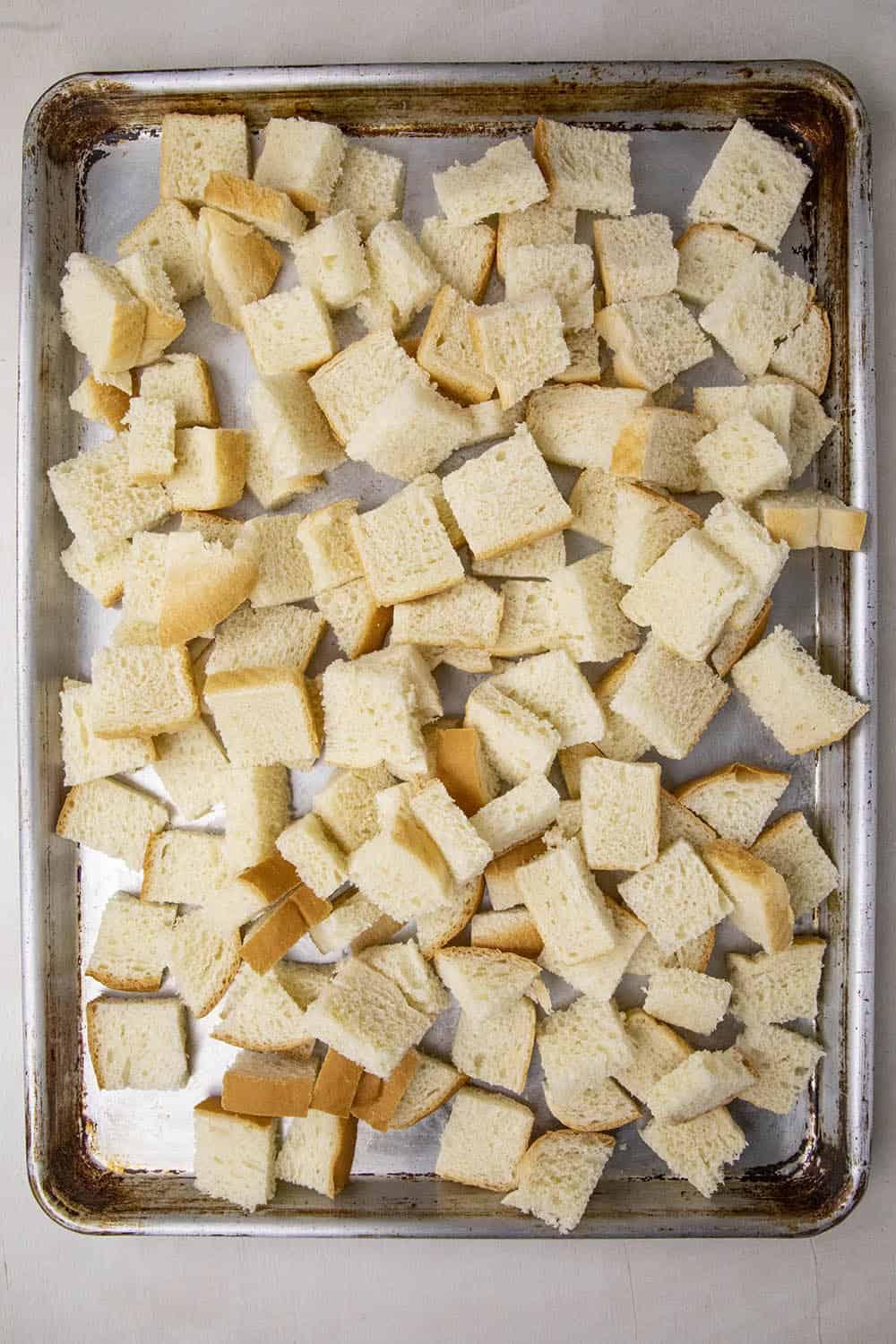 Cubed bread on a baking sheet, ready to dry out